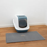 Closed cat litter box with flap and ventilation slots, grey mat in front on wooden floor.