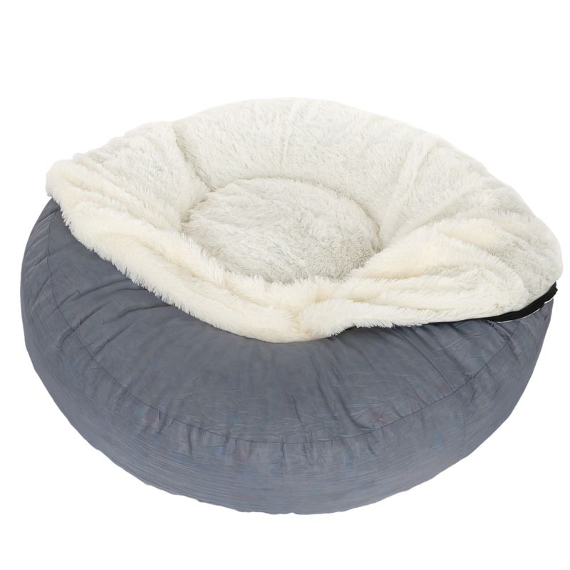 Round, grey pet bed with soft, white plush padding and raised edge.