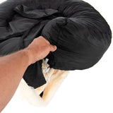 Hand demonstrating how to remove or adjust the black cover from a round, padded pet bed with a drawstring fastening.