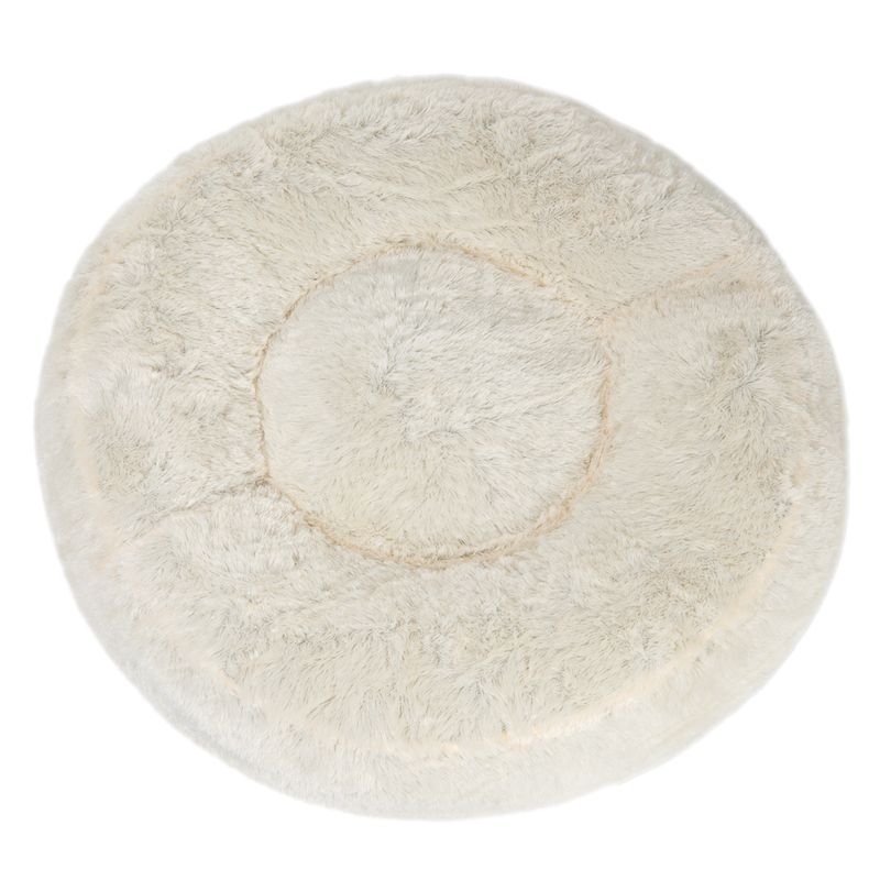 Round, plush, cream-coloured pet bed with a raised edge and soft, fluffy texture, shown from above to display its circular shape and cushioned centre.