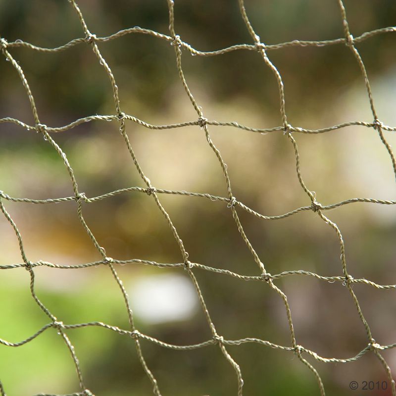 Close-up of sturdy mesh fabric made of green material, suitable for various outdoor applications.