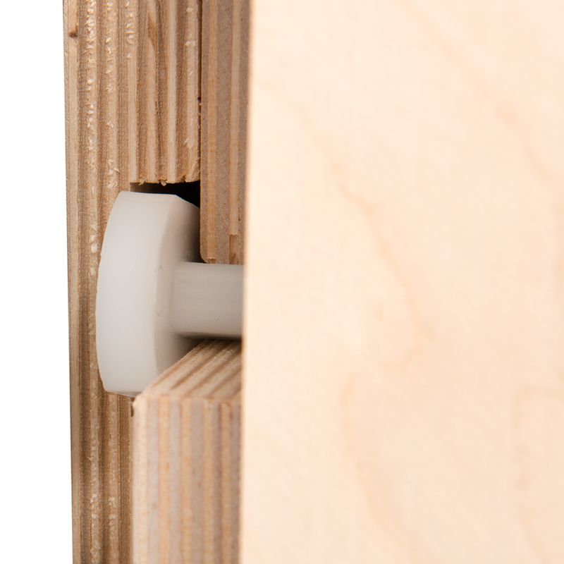 Close-up view of a wood joint with plastic roller, showing precise workmanship and combination of wood and plastic materials.