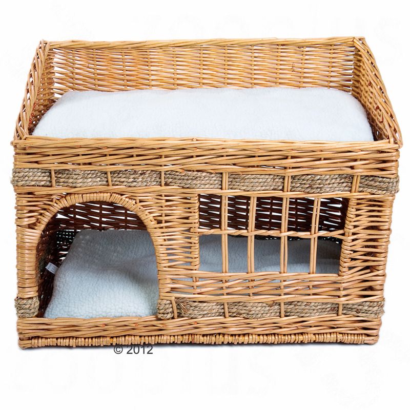 Braided rattan basket with two levels, white padded lying surfaces and an entrance on the lower level.