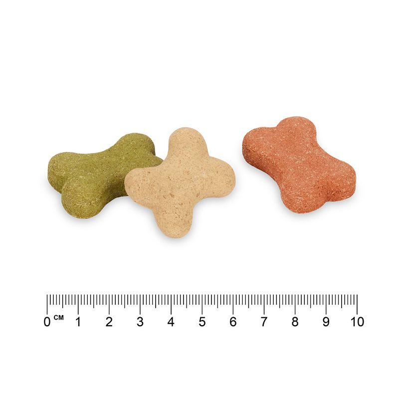 Three bone-shaped dog snacks in green, beige and red. Scale below shows length of approx. 5 cm.