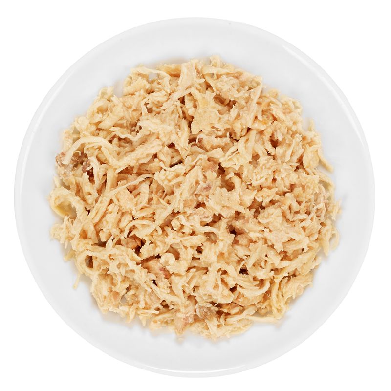 Close-up of shredded, cooked chicken meat on a white plate.