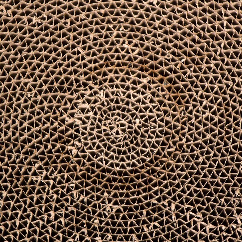 Close-up of a spiral corrugated cardboard structure, suitable for scratching surfaces or cardboard toys.