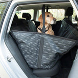 Dog sitting on a black car seat cover with safety belt, suitable for the back seat. Seat cover protects seats from dirt and pet hair.