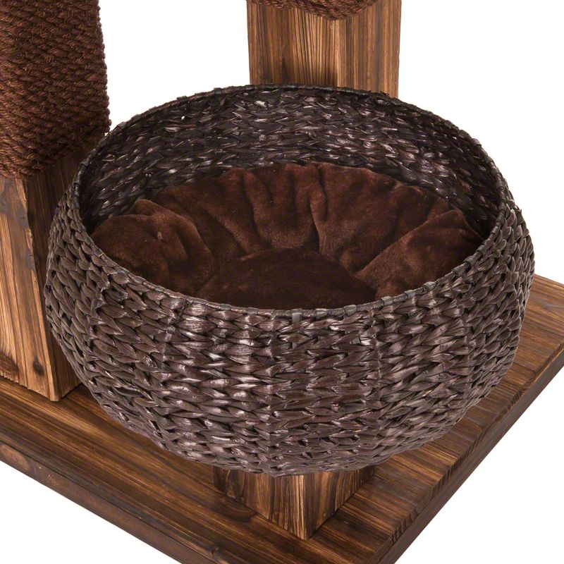 Round basket made of brown woven material with a soft, dark brown cushion on a wooden platform.