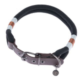 Black collar made of braided fabric with brown and white accents, metal clasp and leather details. Pendant with NT logo visible.