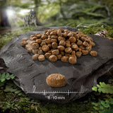 Dry food in brown pellets on stone plate, size 8-10mm according to scale.